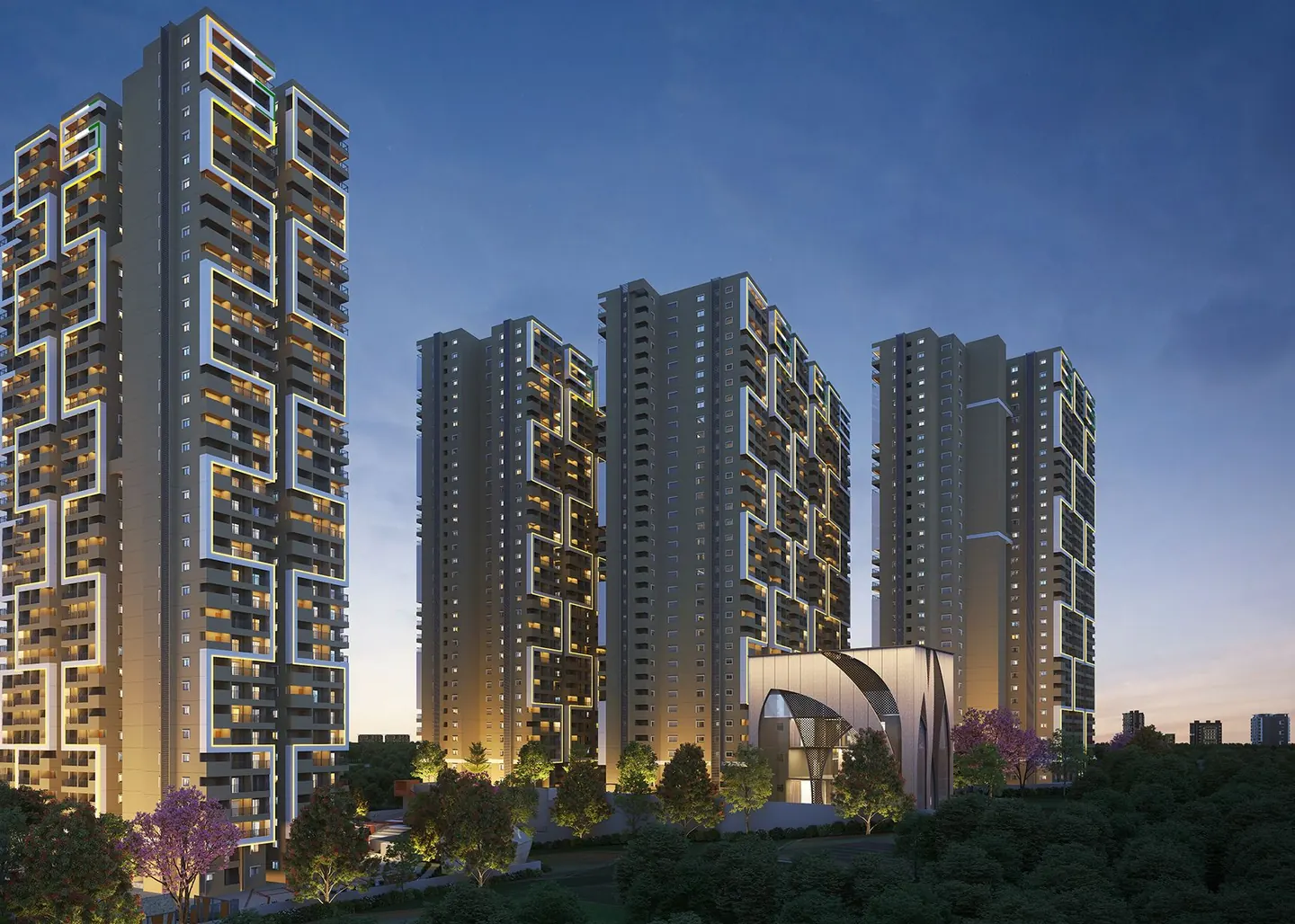Apartment towers outlined in light at dusk above trees in bloom at Candeur Eternia